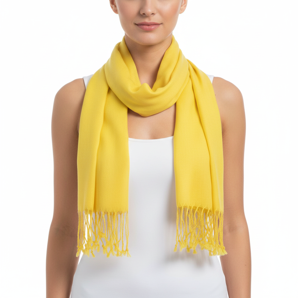 A woman wearing a bright yellow scarf with fringe ends, styled around her neck over a white sleeveless top against a plain white background.