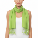 A woman wearing a bright lime green scarf with fringed ends, draped around her neck over a white sleeveless top against a plain white background.