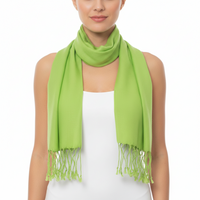 A woman wearing a bright lime green scarf with fringed ends, draped around her neck over a white sleeveless top against a plain white background.
