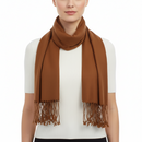 A woman wearing a warm brown scarf with fringe details, styled over a white ribbed short-sleeve top against a plain white background.