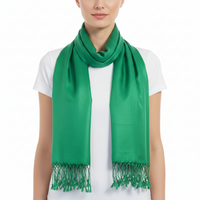 A bright green scarf with fringed ends, worn around the neck of a model wearing a white t-shirt against a plain white background.