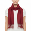 A model wearing a deep red scarf with fringed ends, styled over a white short-sleeve top against a plain white background.