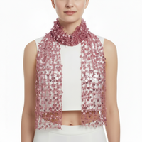 Person wearing a pink beaded scarf over a white top and pants on a white background