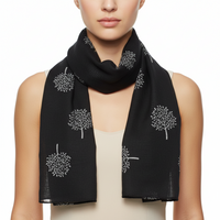 A black scarf with white printed tree patterns.