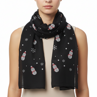 A black scarf with a pattern of snowflakes and snowmen.