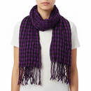A purple checkered print scarf with tassels spread out on a plain surface.