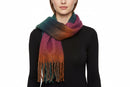 A multicolored striped winter scarf with tassels spread out on a plain surface.