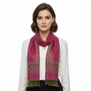 A fuchsia pink pashmina with paisley print border and fringes displayed on a flat surface.