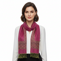 A fuchsia pink pashmina with paisley print border and fringes displayed on a flat surface.