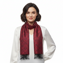 A woman with short dark hair wearing a white blouse and a dark red patterned scarf with black fringe, photographed against a plain white background.