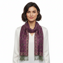 A woman with short dark hair wearing a white top and a purple patterned scarf with fringed ends, photographed against a plain white studio background.