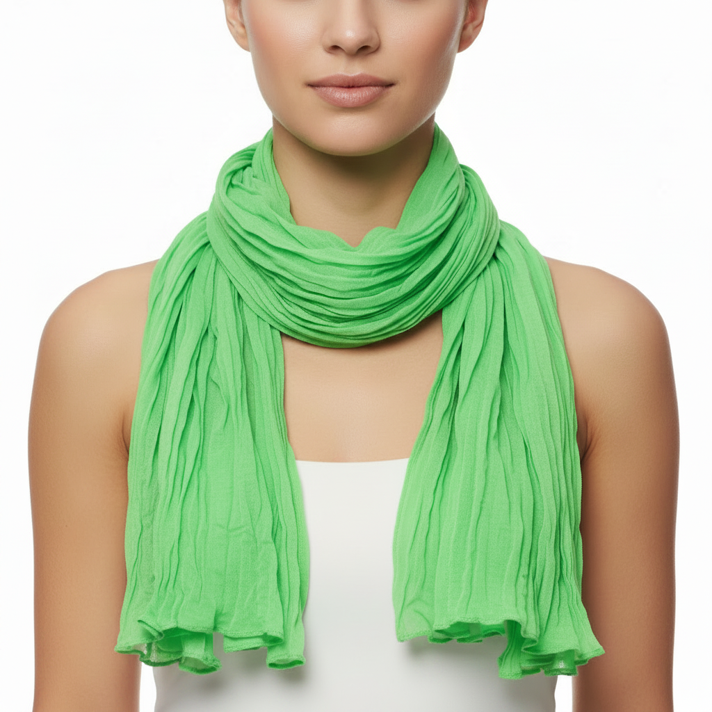 A green soft wrinkled scarf draped and displayed on a plain background