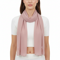 A dusty pink chiffon scarf draped and laid out on a plain surface.