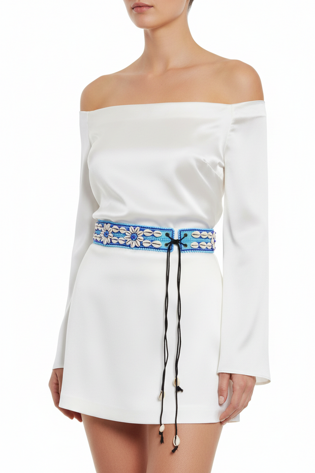 A blue and white beaded belt with adjustable strings, featuring a floral pattern and seashell designs.