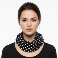 Woman wearing a black scarf with white polka dots on a white background