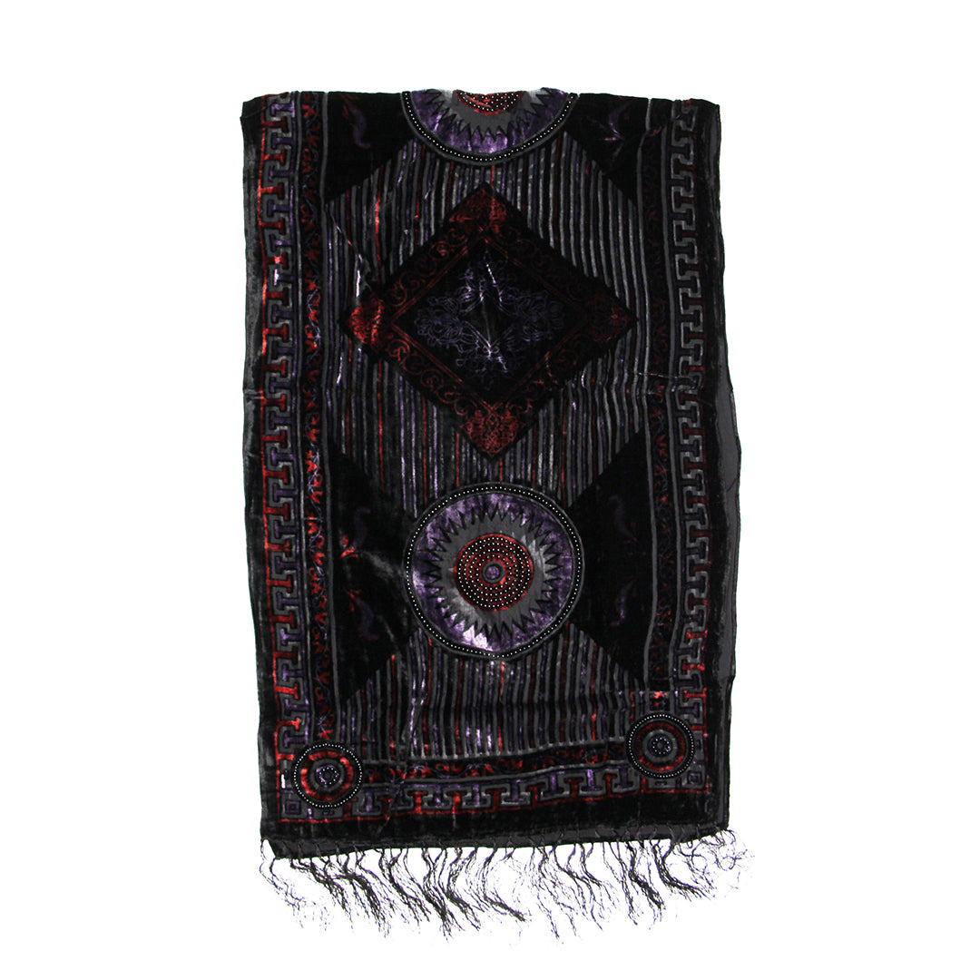 A black embroidered prayer shawl with intricate geometric and circular patterns in red, purple, and silver, featuring fringe at the bottom, shown against a plain white background.