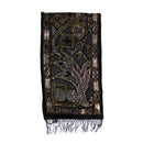 A black embroidered scarf with intricate gold, brown, and silver floral and geometric patterns, finished with a fringed hem, shown against a plain white background.