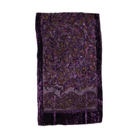 A rectangular purple velvet textile, likely a decorative rug, runner, or table runner, featuring an intricate paisley and floral pattern in metallic gold, bronze, and pink accents, displayed flat against a white background.