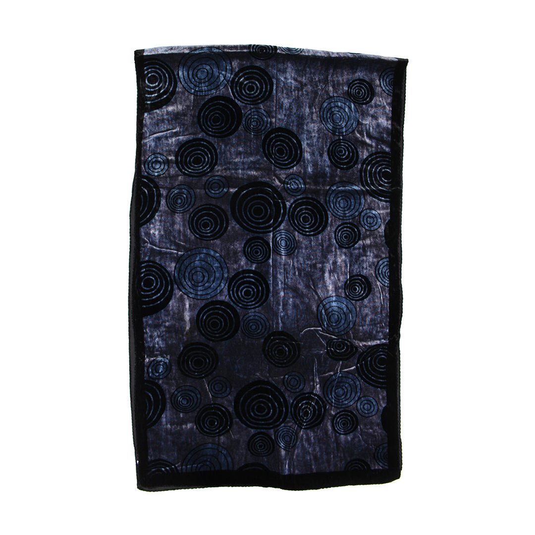 A rectangular black fabric item, likely a scarf or small bag, featuring an all-over abstract pattern of concentric circles in black and dark blue on a textured background.