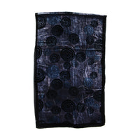 A rectangular black fabric item, likely a scarf or small bag, featuring an all-over abstract pattern of concentric circles in black and dark blue on a textured background.