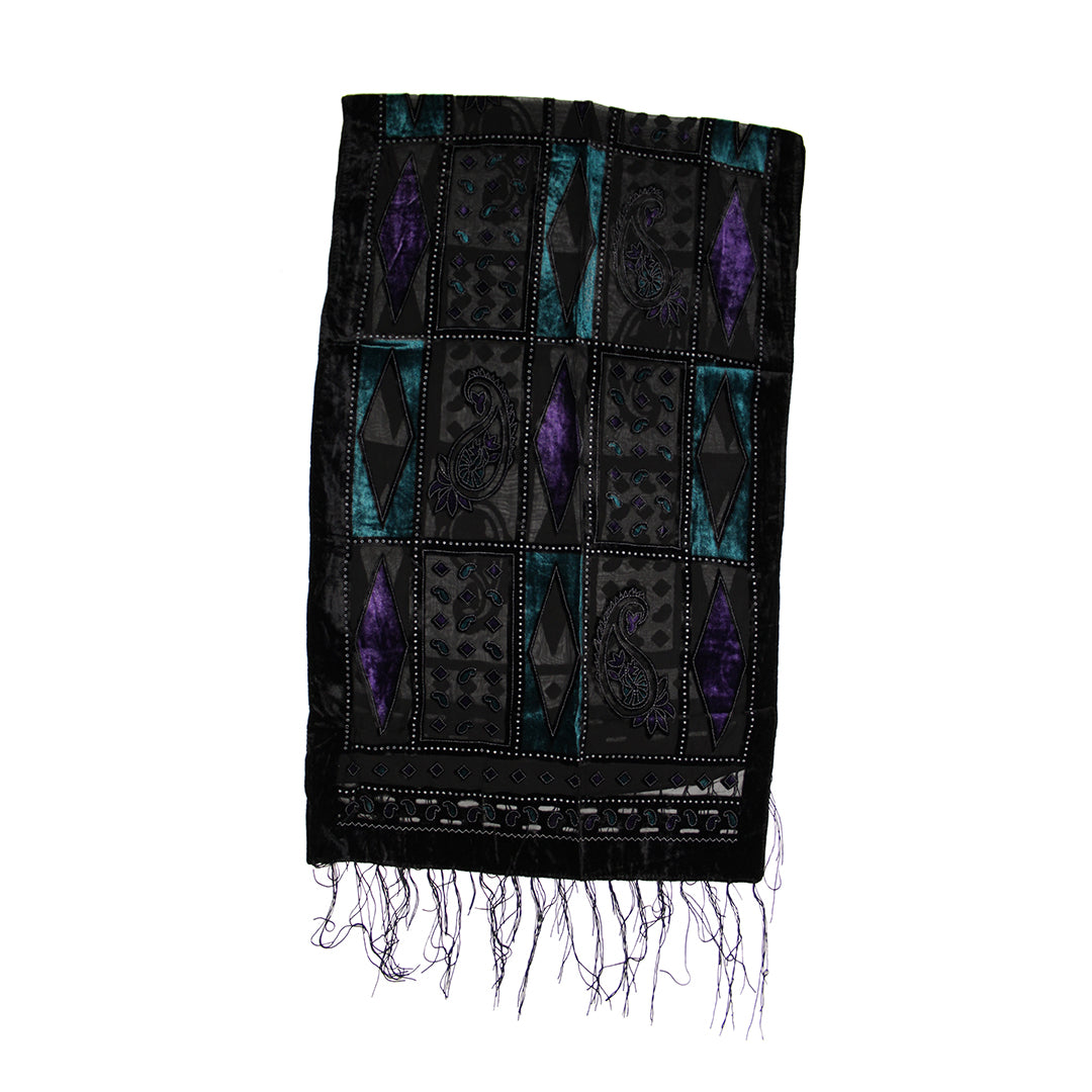 A black woven textile with geometric and diamond patterns in purple and teal, finished with fringed edges, shown against a plain white background.