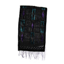 A black woven textile with geometric and diamond patterns in purple and teal, finished with fringed edges, shown against a plain white background.