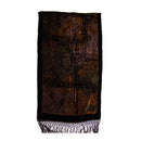 A rectangular scarf with fringed ends, featuring an abstract, distressed pattern in black, brown, and bronze tones with a subtle central emblem.