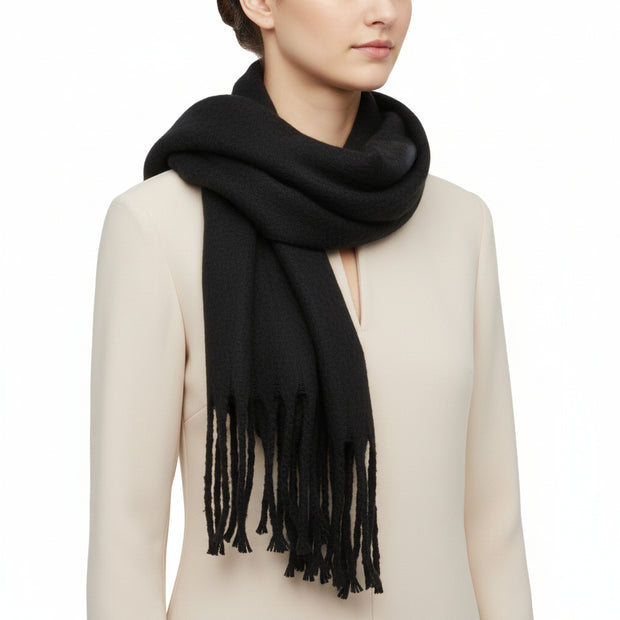 A black, solid-colored, fluffy thick winter scarf with fringed ends.